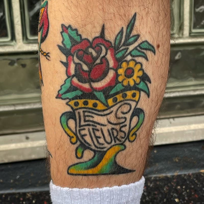 Traditional vaas met roos en 'LE FLEURS' tekst.