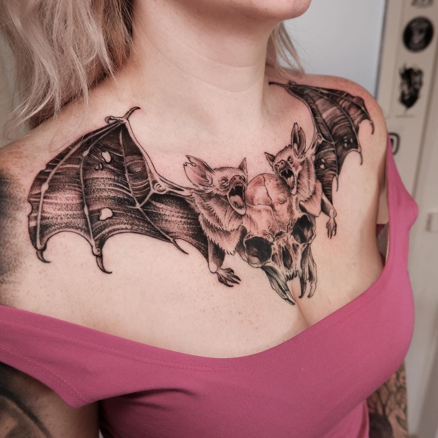 Grote borsttattoo van een schedel met twee vleermuizen.