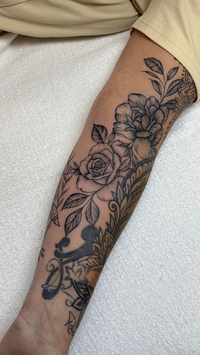 Zwart-wit fineline bloemen en mandala op onderarm.