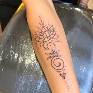 Fineline lotus unalome tattoo op onderarm.