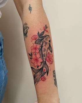 Koi vis met roze kersenbloesems op onderarm.