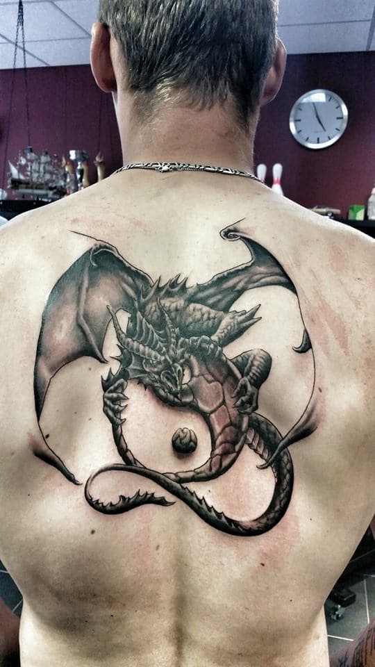 Grote realistische draak in cirkel op bovenrug.