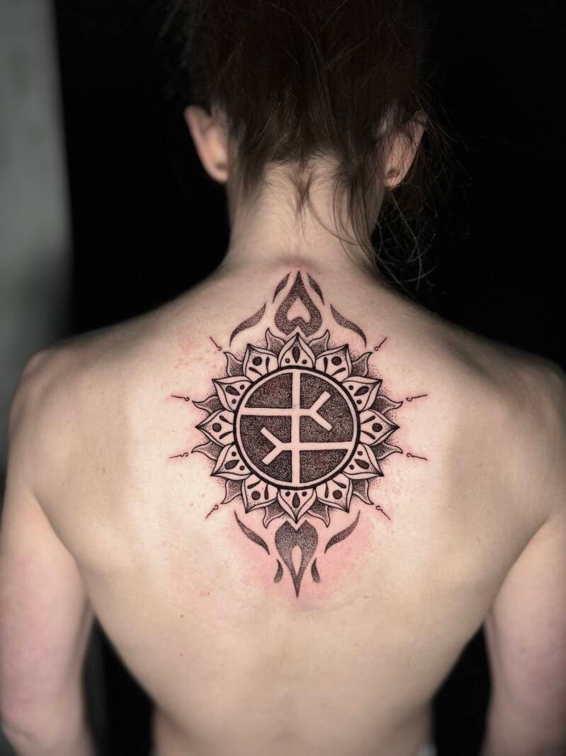 Grote dotwork mandala met runen op de bovenrug.