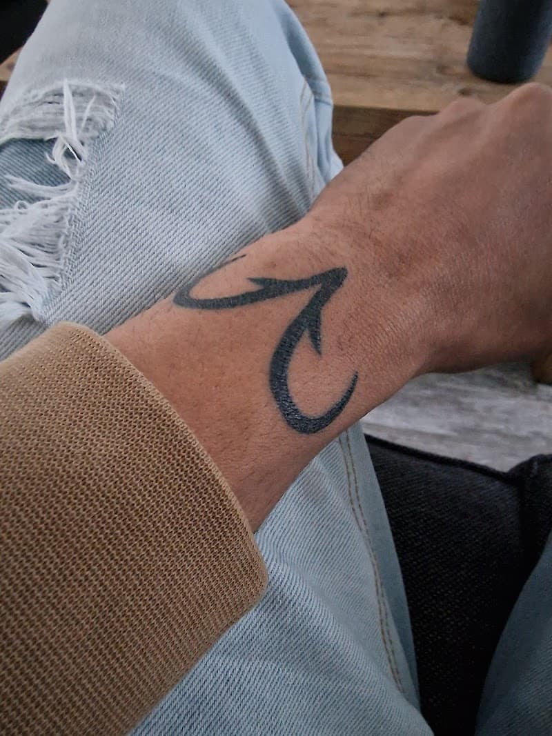 Zwarte tribal-achtige tattoo op de pols.