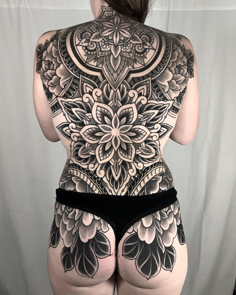 Grote zwart-wit mandala en bloemen backpiece tattoo.