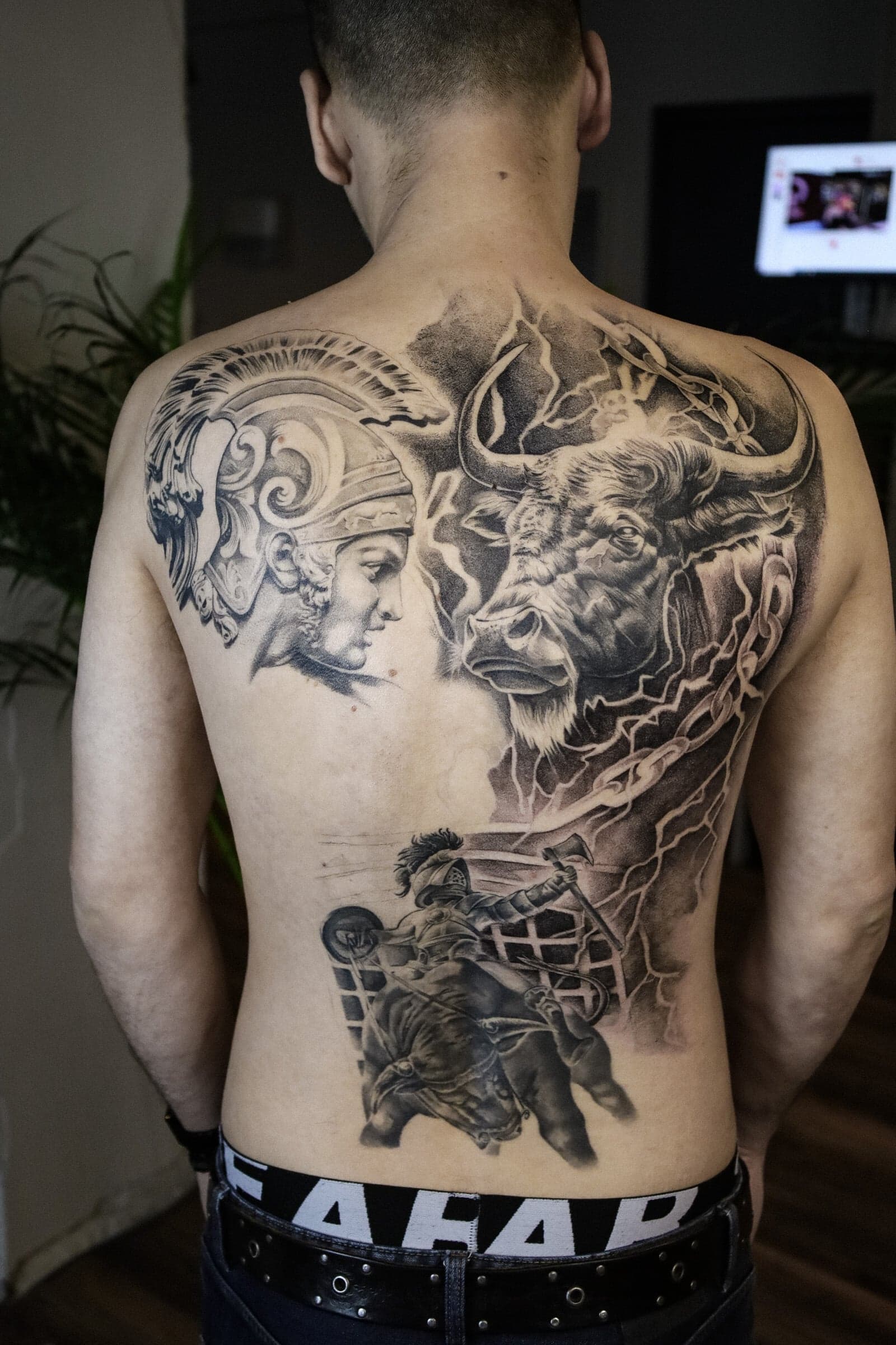 Grote rugtattoo met Romeinse soldaat, stier en gladiatorgevecht in zwart-wit.