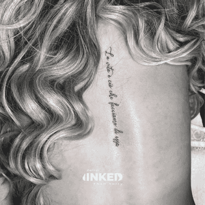 Elegante fineline script tattoo langs de ruggengraat.