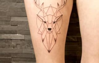 Geometrische hertenkop tattoo op bovenbeen.