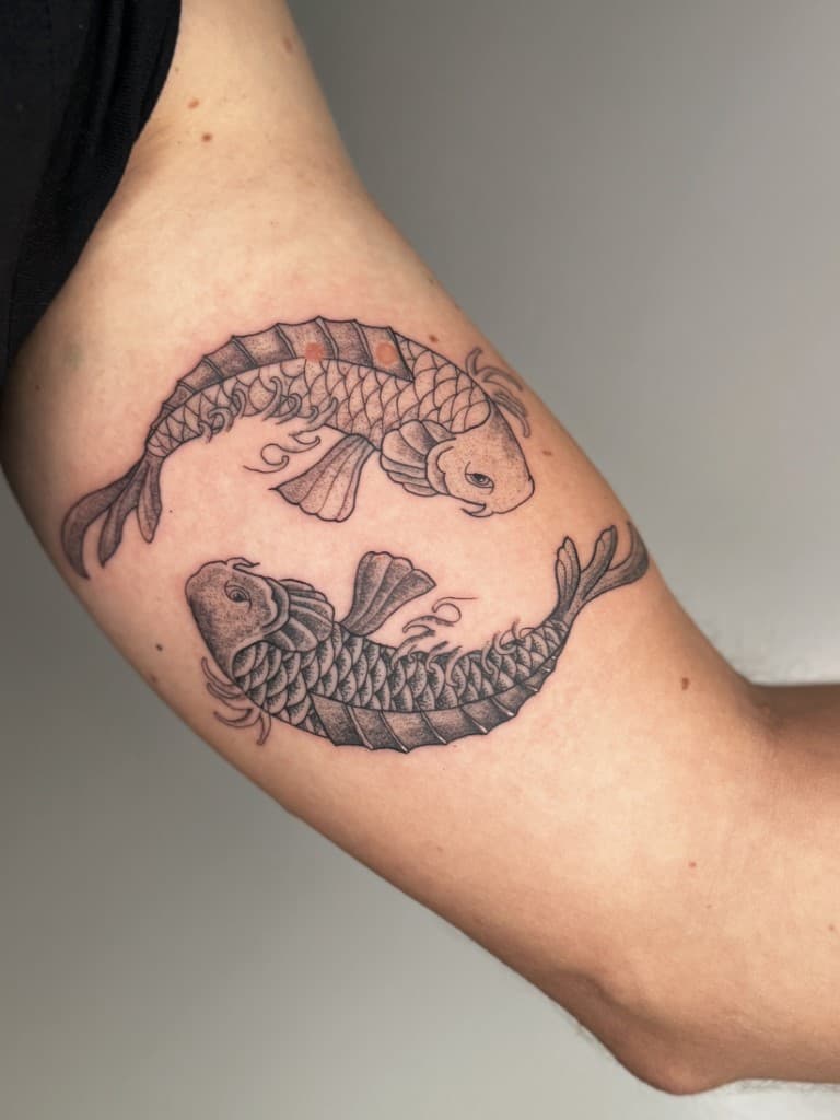 Twee koi vissen in yin-yang formatie, uitgevoerd in dotwork stijl.
