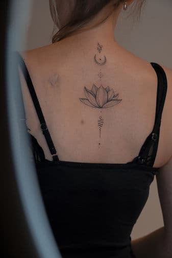 Fineline lotusbloem met maan, sterren en unalome op de rug.