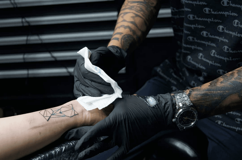 Geometrische lijnwerk tattoo op de pols, net gezet.