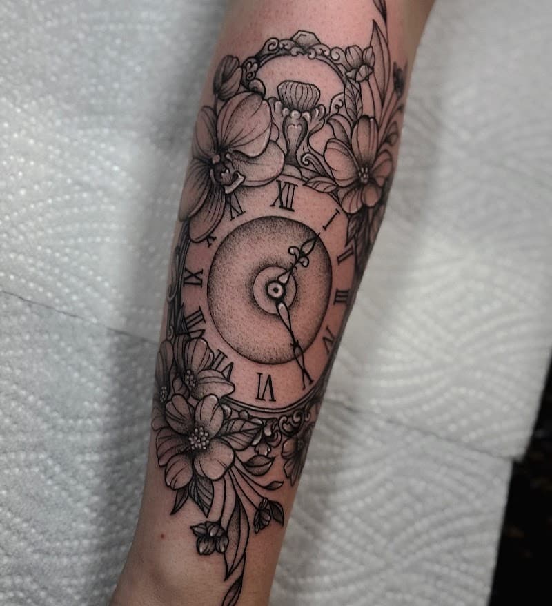 Zwart-wit zakhorloge met bloemen en Romeinse cijfers op onderarm.