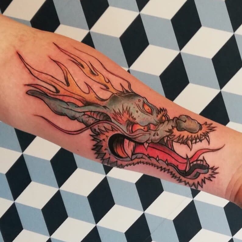 Close-up van een Japanse drakenkop tattoo op de onderarm.