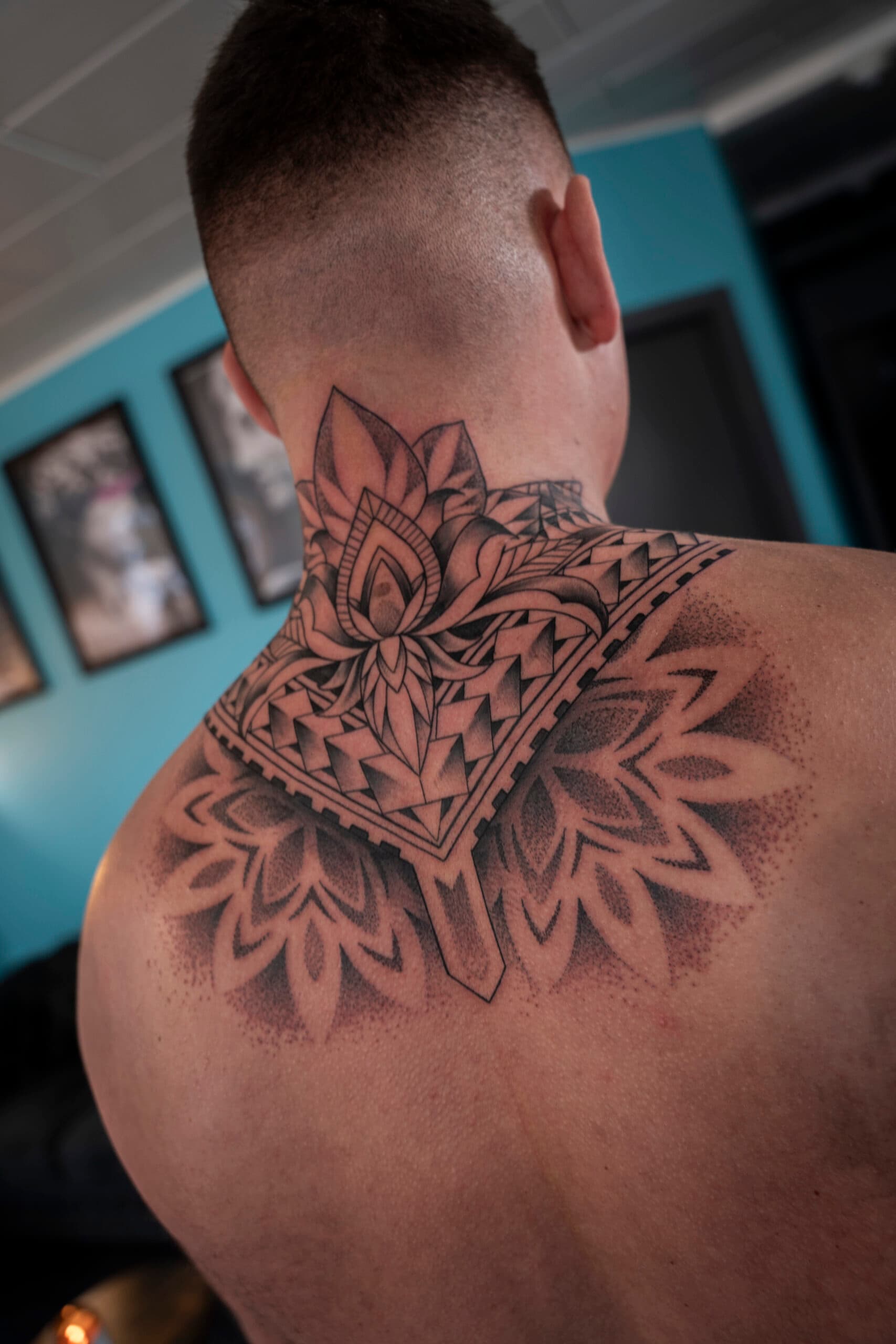 Geometrische mandala en lotus tattoo op nek en bovenrug.