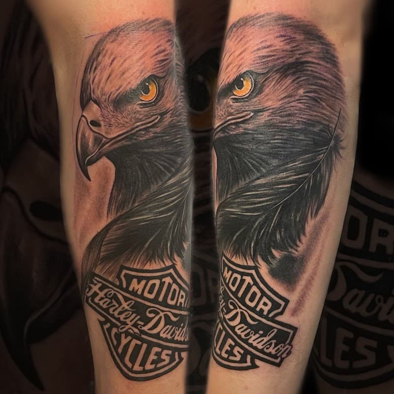 Realistische adelaarskop met Harley-Davidson logo op onderarm.