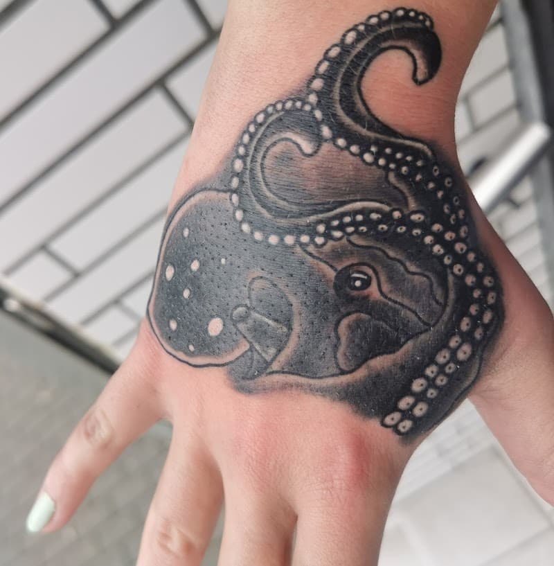 Zwart-wit octopus tattoo op de hand.