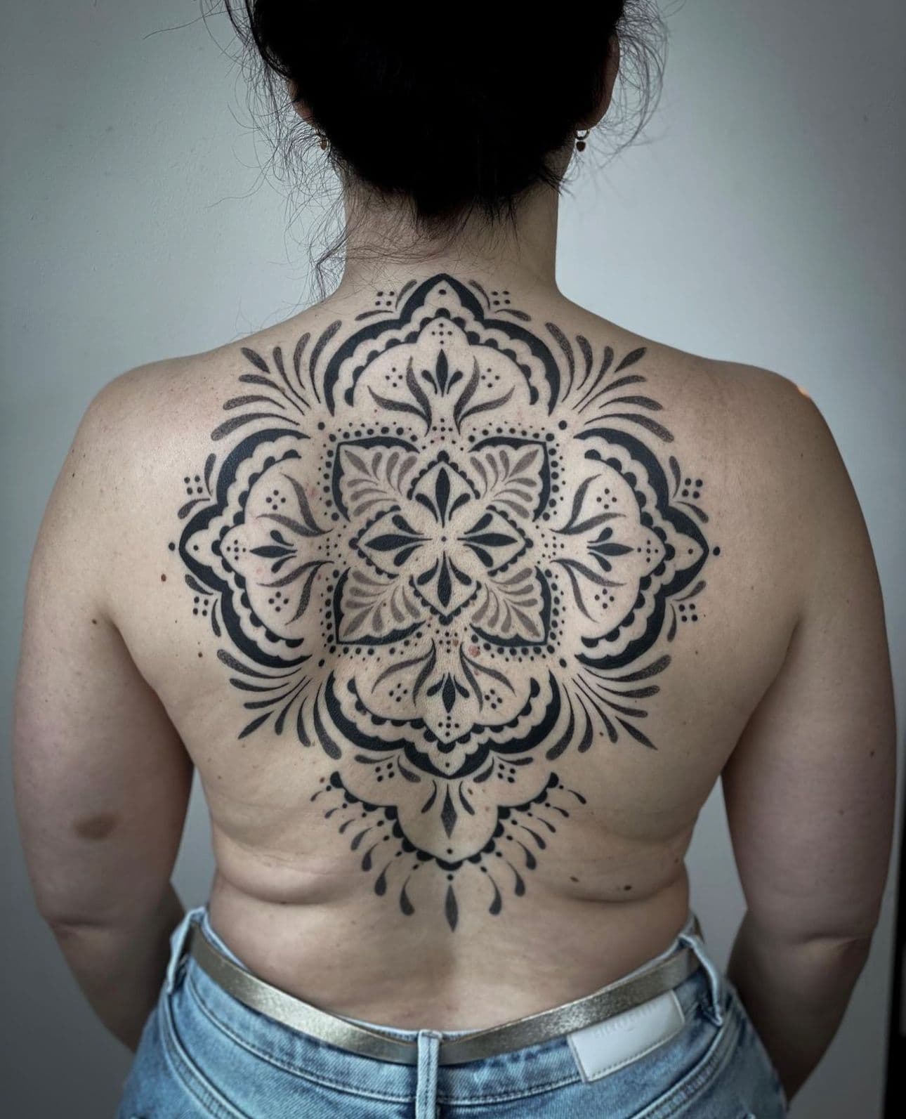 Grote mandala tattoo op de volledige rug in dotwork en blackwork stijl.